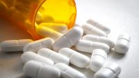 Stock image of pills spiling out of a prescription bottle.